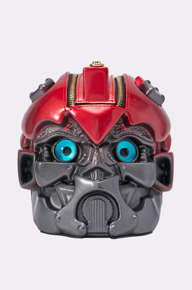 Introducing the OPTIMUS FYYNE BAG: a compact, metallic red and gray novelty handbag crafted in the shape of a robot head, featuring striking blue eyes, a top zipper closure, and detailed mechanical accents—ideal for festivals or standout outings.
