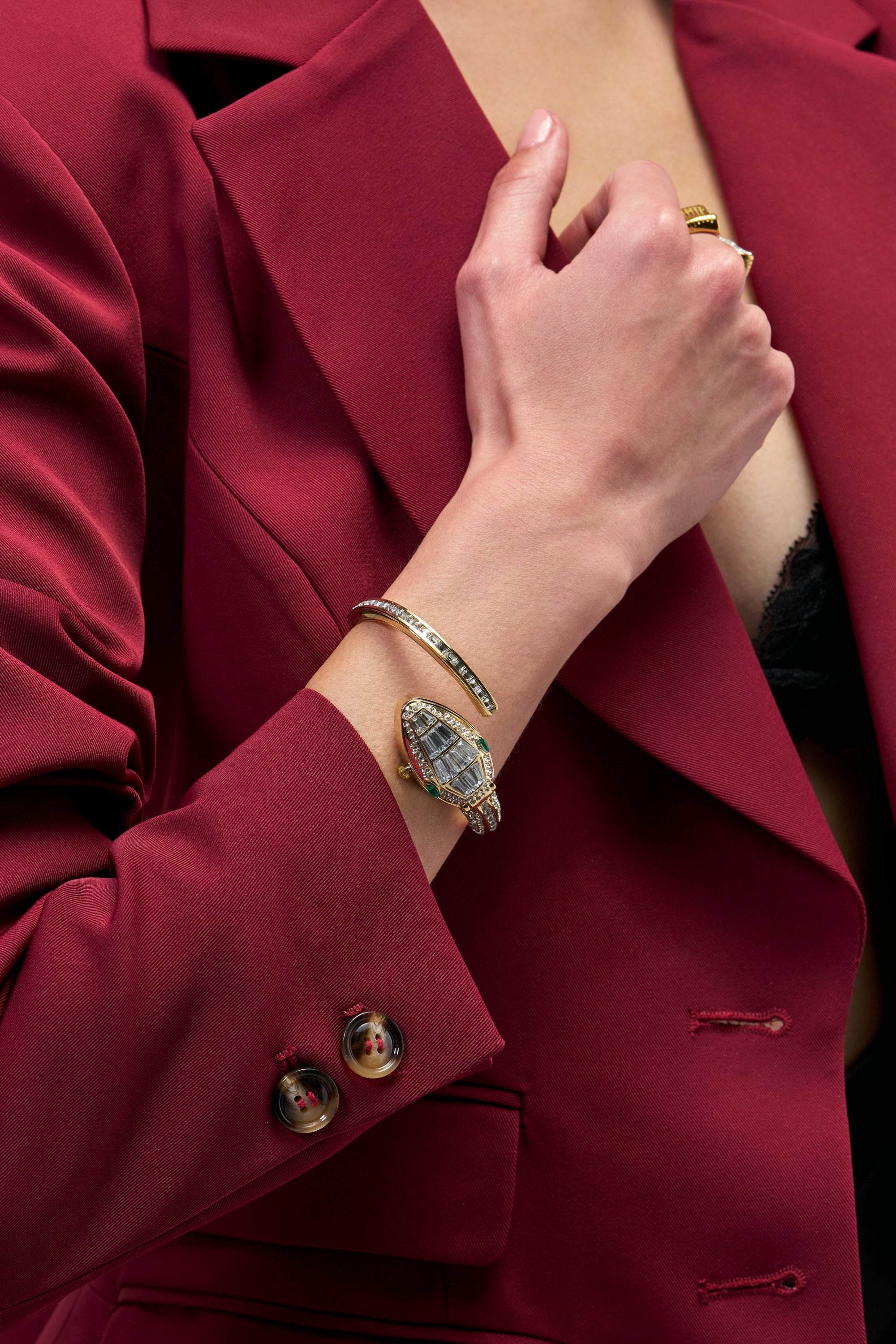 A silver VENOM KISS WATCH IN SILVER snake watch with a crystal-encrusted head and band worn as a statement piece on a person’s wrist.