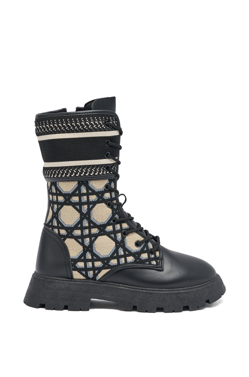 The AMADA CANVAS PRINT COMBAT BOOT is a black canvas combat boot with chunky sole, beige mesh panels, a geometric black pattern, faux leather trim, black laces, and decorative stitching—ideal for streetwear enthusiasts.