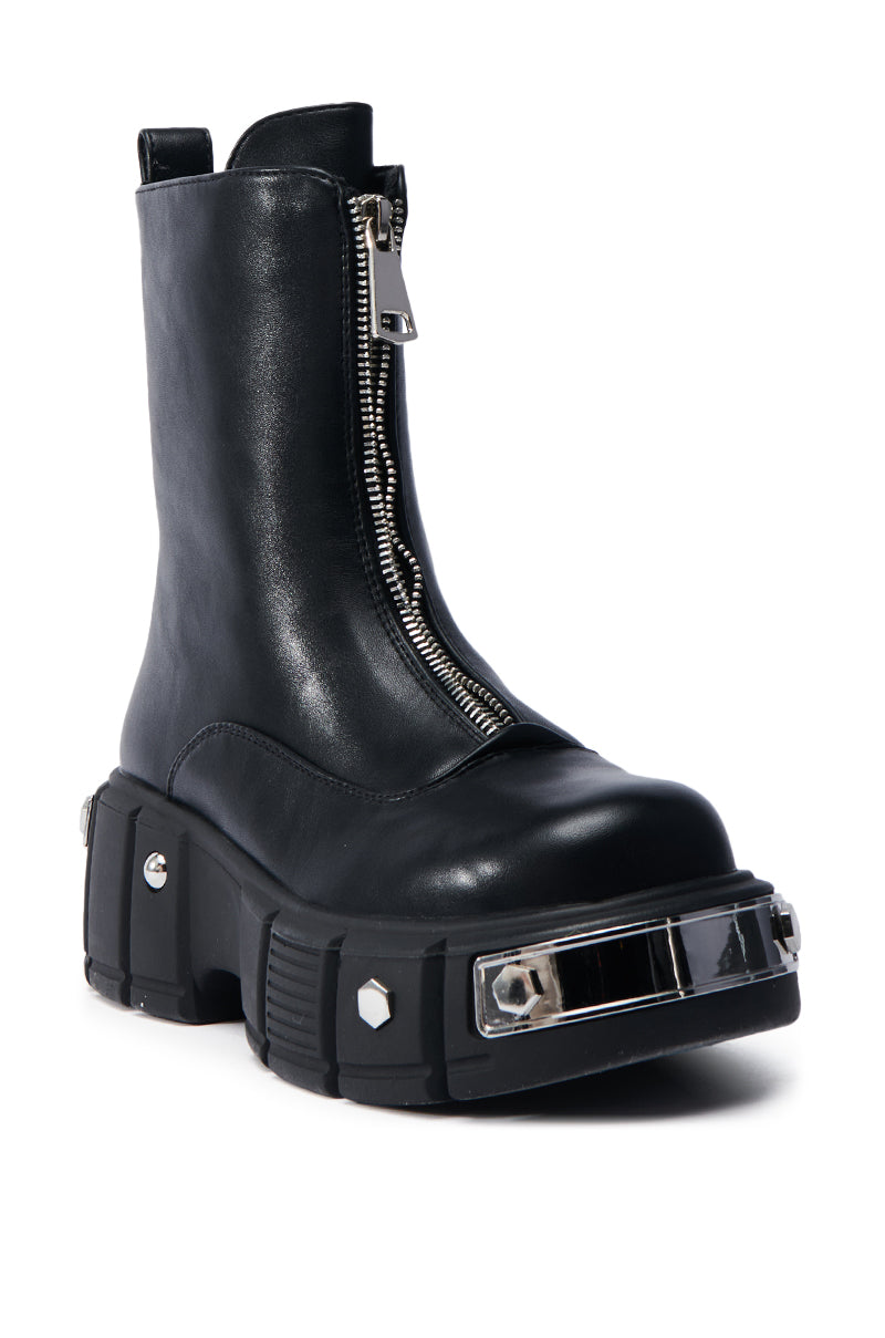 The AZALEA WANG AMARANTA BLACK BOOTIE features a black faux leather design with a chunky platform lug sole, front zipper, metallic embellishments, and a transparent section for added style and edge.