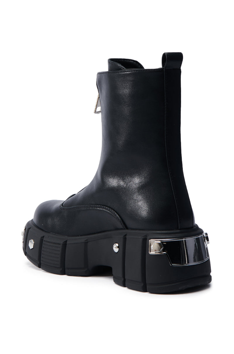 The AZALEA WANG AMARANTA BLACK BOOTIE boasts a black faux leather design with a platform lug sole, featuring chunky rubber and metallic heel accents. The slightly raised back and handy pull tab enhance its elegant rear side profile.
