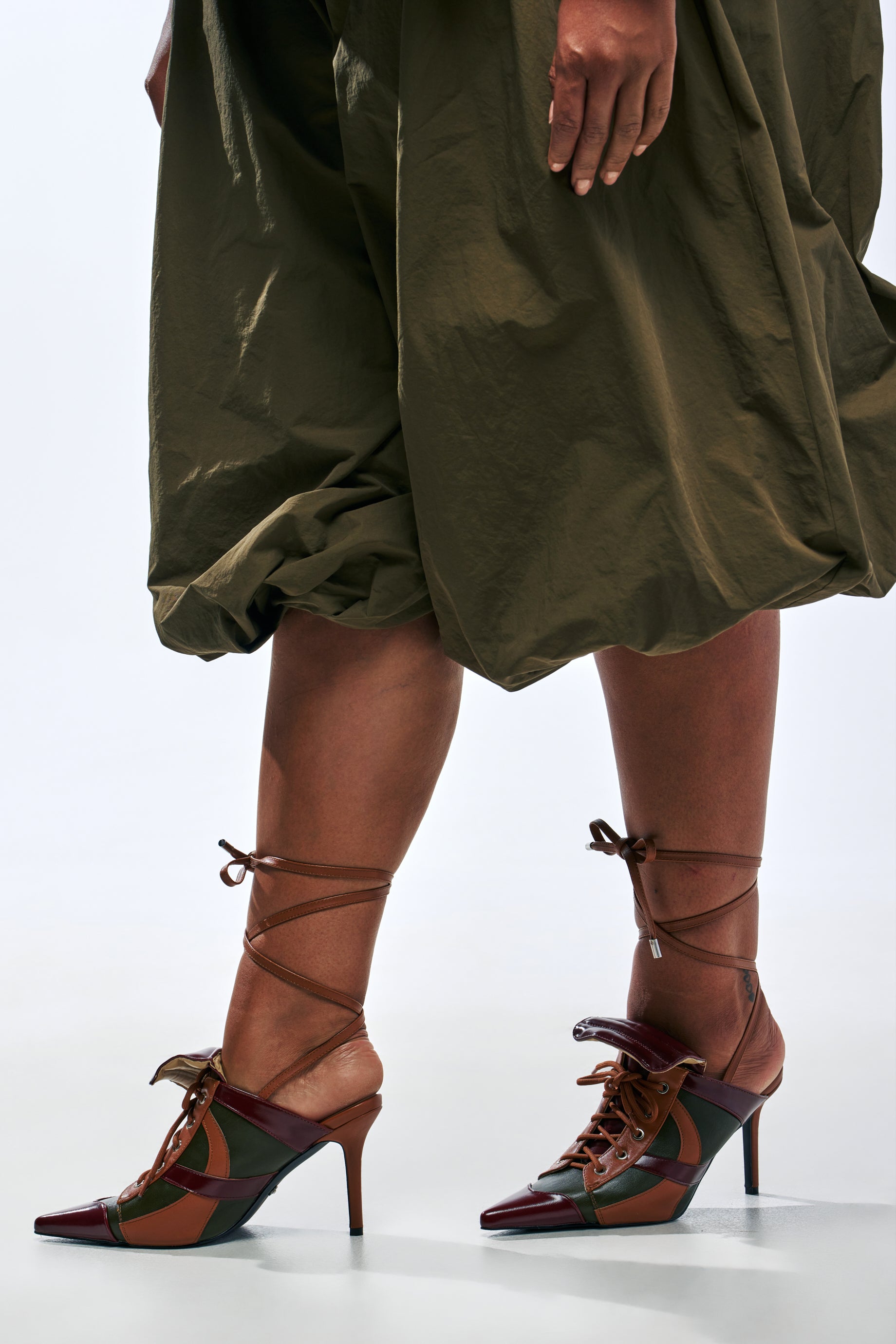 AZALEA WANG AMBRE OLIVE COLORBLOCK MULTI MULE LACE UP STILETTO PUMP with an olive and brown patchwork design, pointed toes, and lace-up ankle straps.