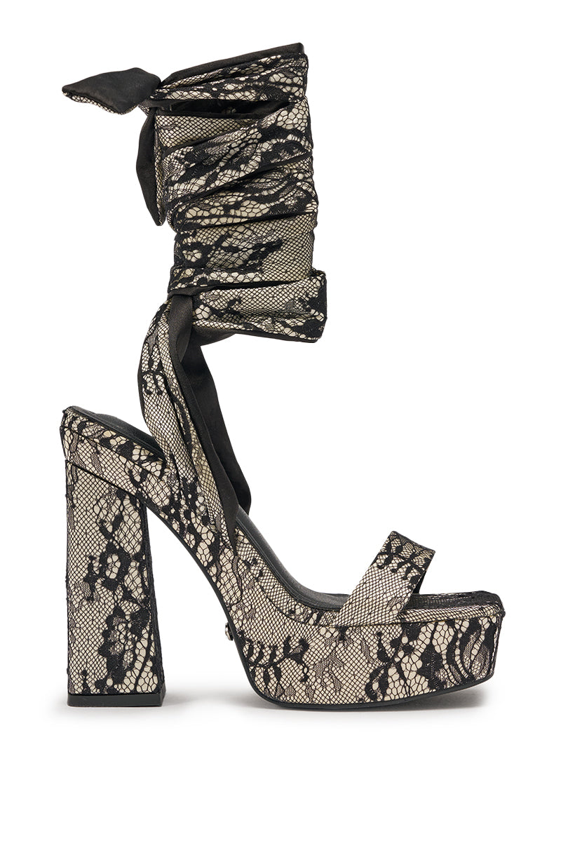 The AKIRA GOLD AMBROISINE BLACK LACE STRAPPY CHUNKY SANDAL features a beige base, high block heel, black lace straps for a lace-up style, and an open toe—offering a classic platform sandal look. 5