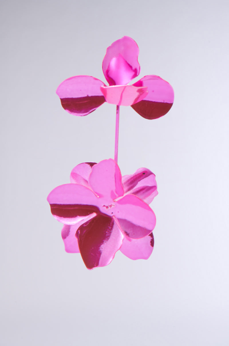 A sleek, contemporary ASH FLOWER EARRING sculpture in hot pink features two blossoms against a plain gray background, with each flower resembling an earring and showcasing smooth, reflective metal surfaces. 8