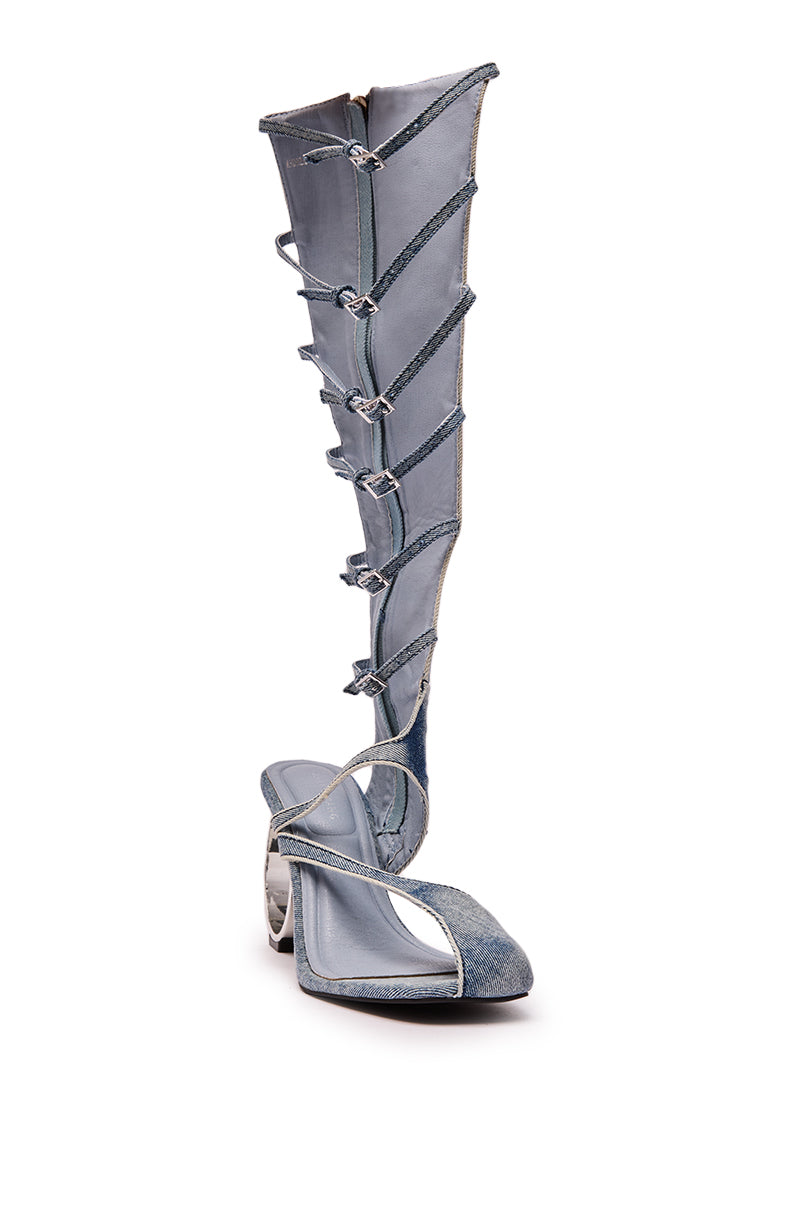 The AZALEA WANG ANDREE DENIM GLADIATOR SANDAL WITH CIRCLE HEEL features knee-high denim, multiple front buckles, and a sculptural circle heel for a bold, modern look.