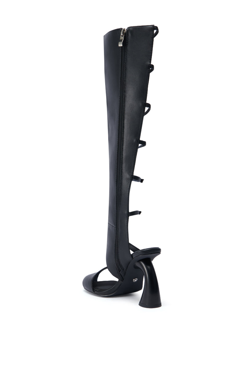 Introducing the AZALEA WANG ANDRIUS BLACK GLADIATOR SANDAL, a sleek and stylish high-heeled shoe with an elongated faux leather leg extension. It features a distinctive spiral hoop design along the side, a convenient rear zipper, an open-toe cut, and a chunky curved block heel for modern flair.