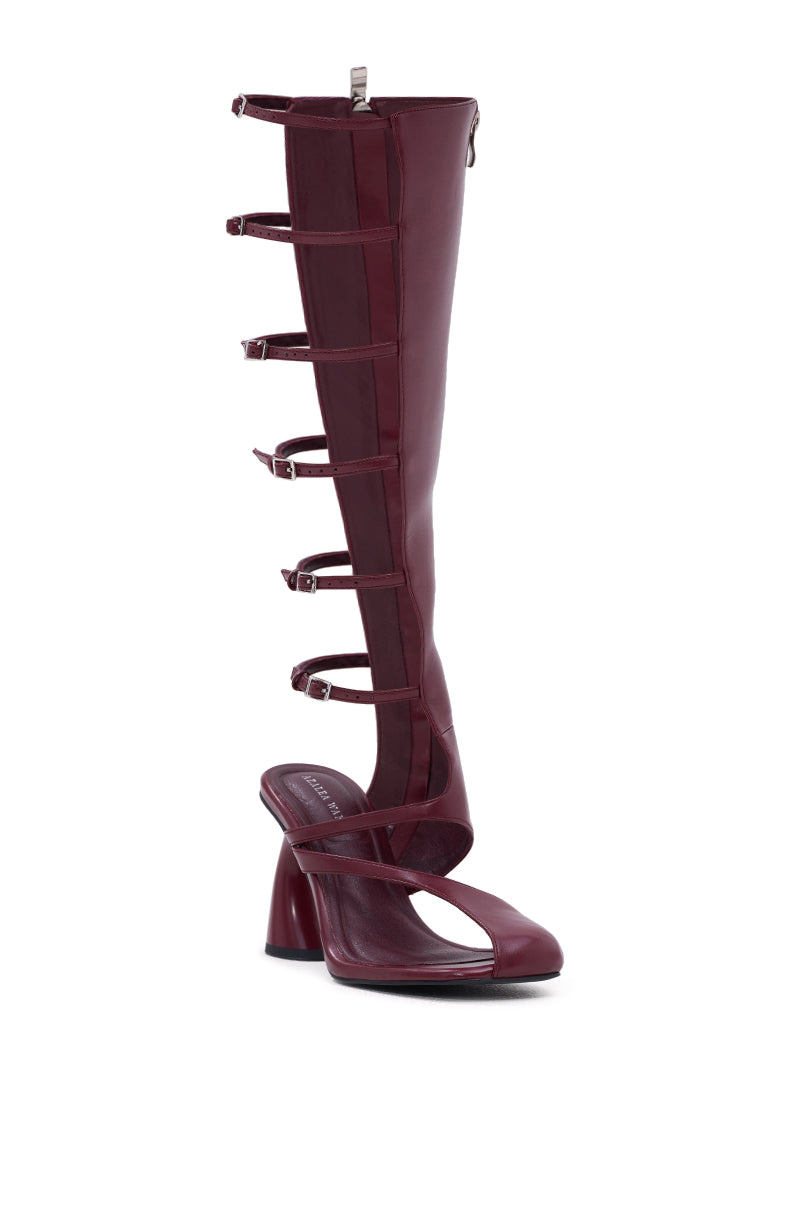 The AZALEA WANG ANDRIUS BURGUNDY GLADIATOR SANDAL is a faux leather, high-heeled sandal boot with a chunky heel, five side buckles, and straps running up to just below the knee.