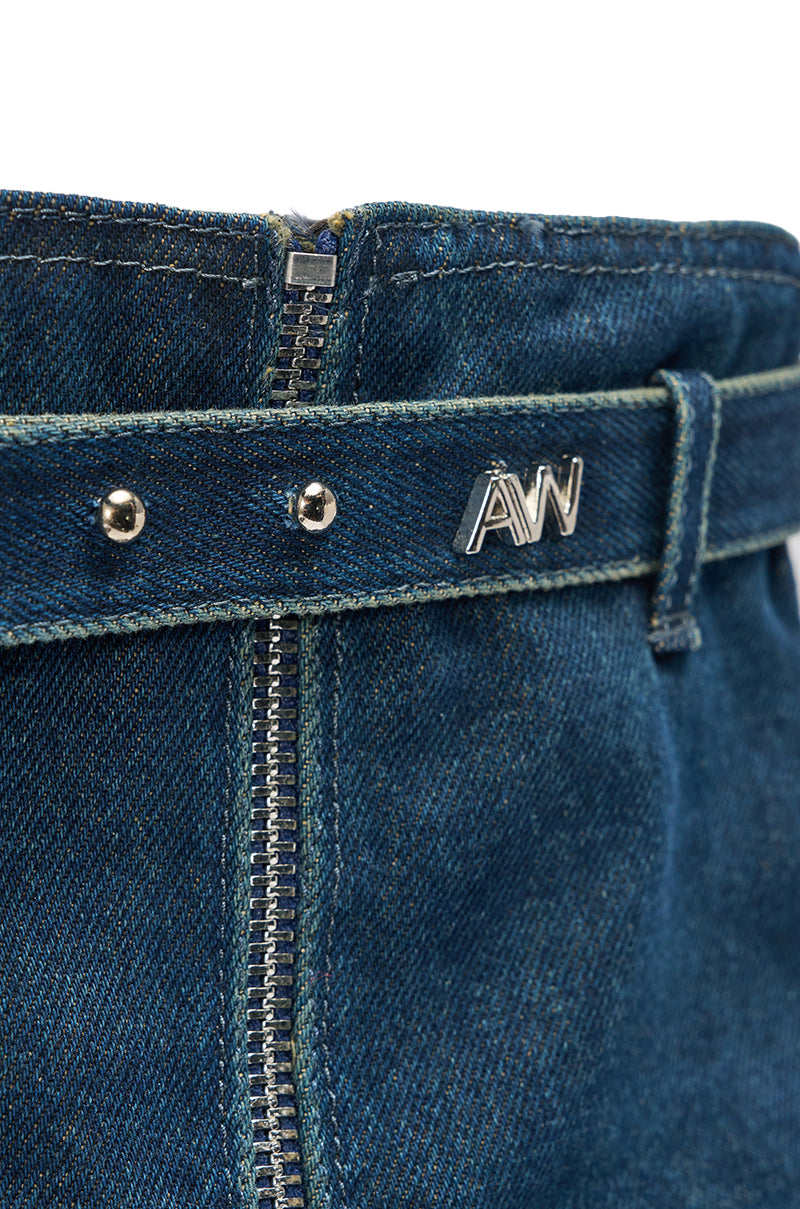 Close-up of blue denim jeans with a metal zipper, two silver rivets, belt loop, and silver “A/W” logo on the waistband—stylishly paired with the AKIRA GOLD ANGELA FOLD OVER PLATFORM BOOT IN DARK DENIM for a bold statement look. 7