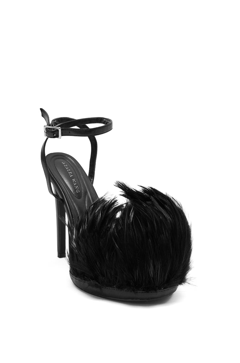 The AZALEA WANG ANGELES BLACK FEATHER STILETTO SANDAL is a black platform heel with an ankle strap and dramatic fluffy black feathers over the toe.
