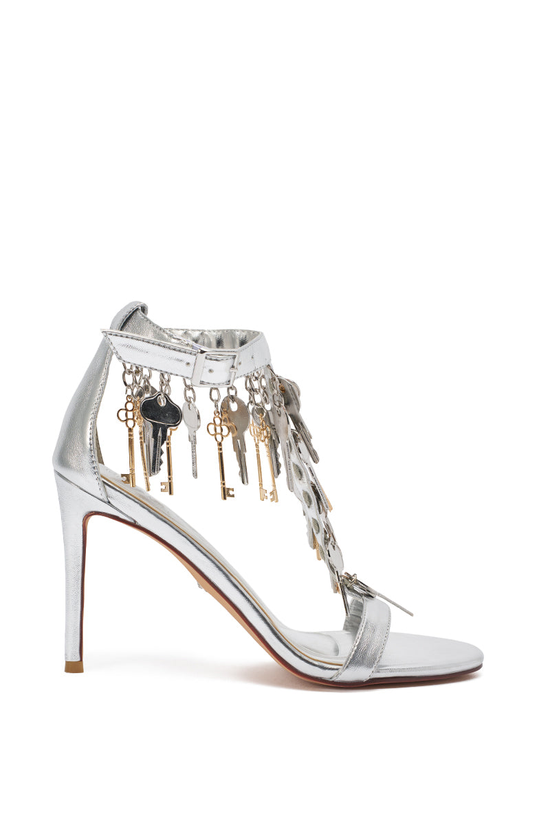 The AKIRA GOLD ANNIKI SILVER KEY EMBELLISHED NOVELTY STILETTO SANDAL features metallic faux leather, an ankle strap, a decorative heel, and key-shaped charms hanging from the upper straps. 4