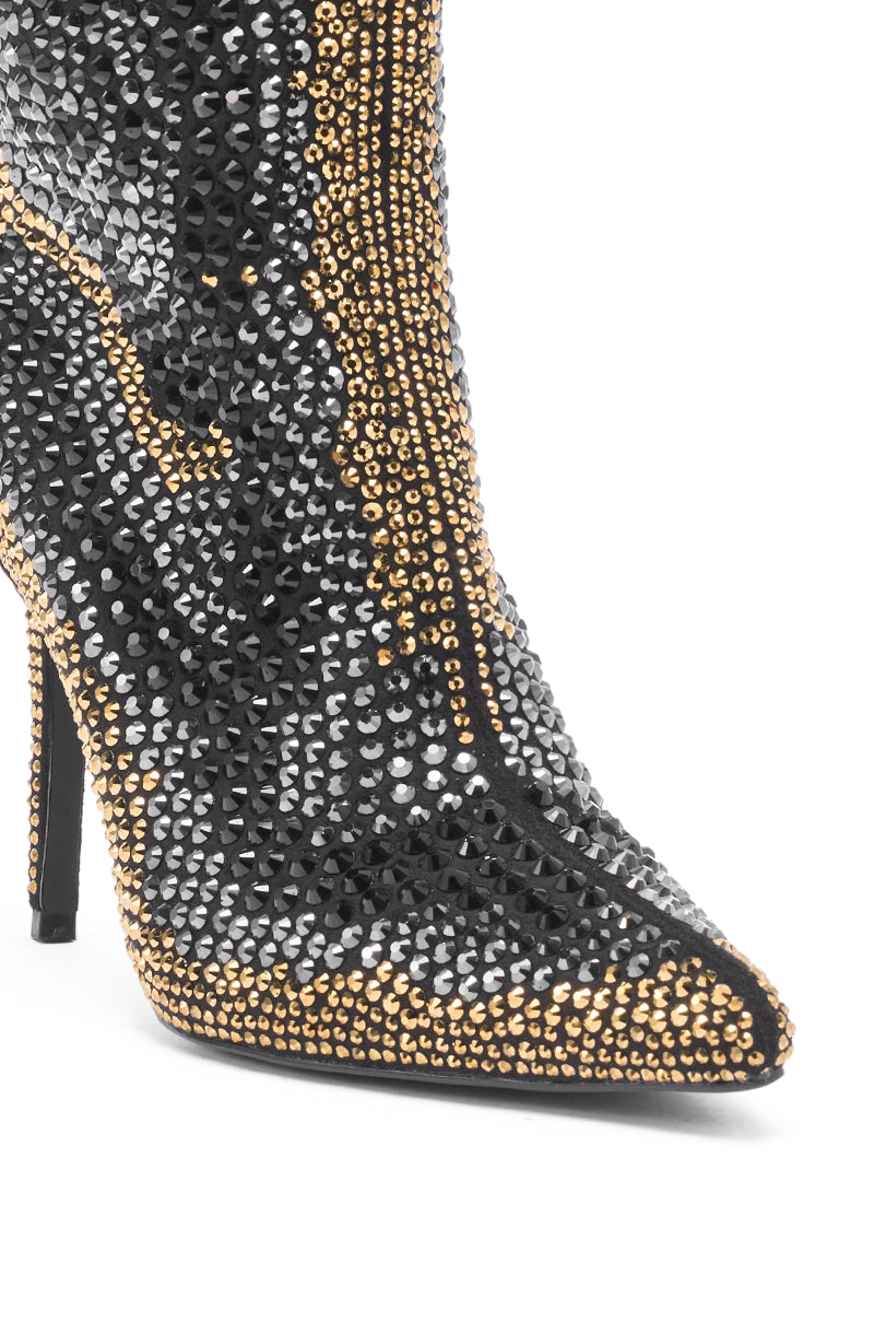A close-up of the AZALEA WANG ANSLEY BLACK MULTI RHINESTONE COCKTAIL BOOTIE, featuring a pointed toe and stiletto heel adorned with black, silver, and gold rhinestones in swirling patterns.