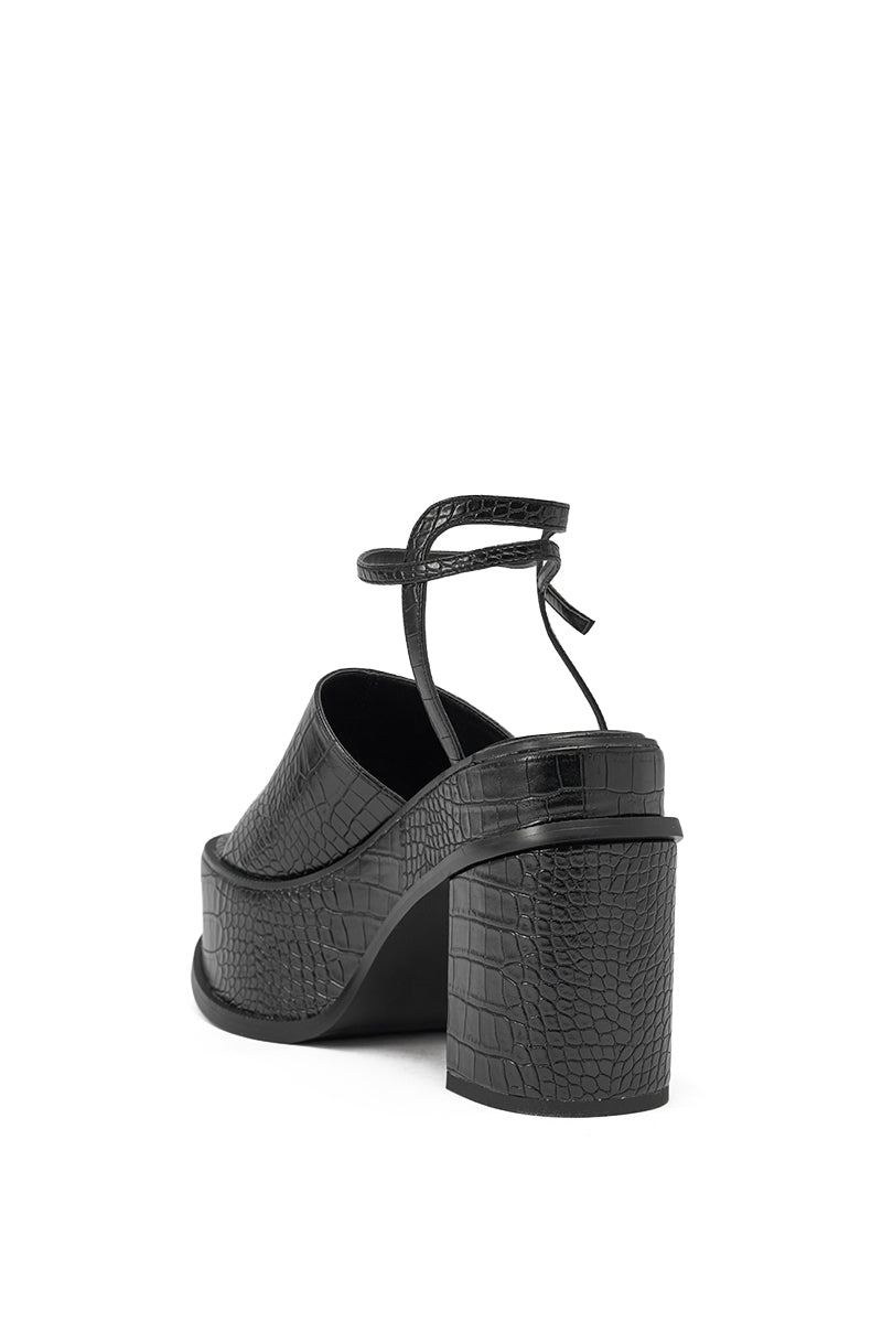 The AZALEA WANG ANTHELMINE BLACK CROC PLATFORM SANDAL features a black faux leather, crocodile-embossed finish, thick block heel, platform sole, and ankle strap—shown from the back on a white background. 5