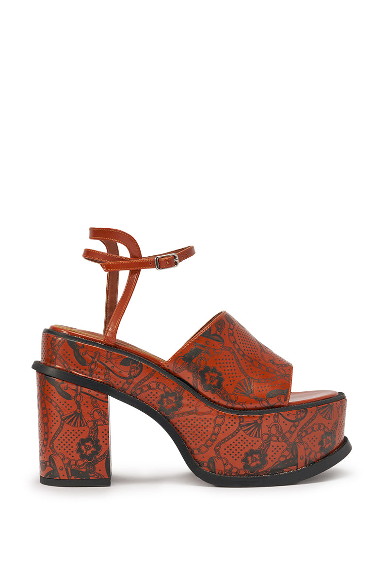 The AZALEA WANG ANTHELMINE COGNAC PLATFORM SANDAL features a chunky block heel, open toe, ankle strap, and bold black floral abstract tattoo detailing across the orange upper, platform, and heel for standout style. 3