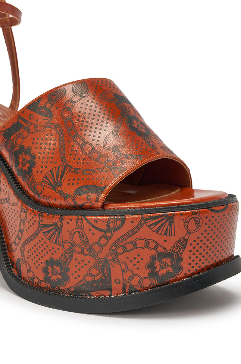 Close-up of the AZALEA WANG ANTHELMINE COGNAC PLATFORM SANDAL featuring orange chain pattern, black floral tattoo detailing, open toe, thick sole, and black trim—ideal for fans of chunky block heel sandals. 6
