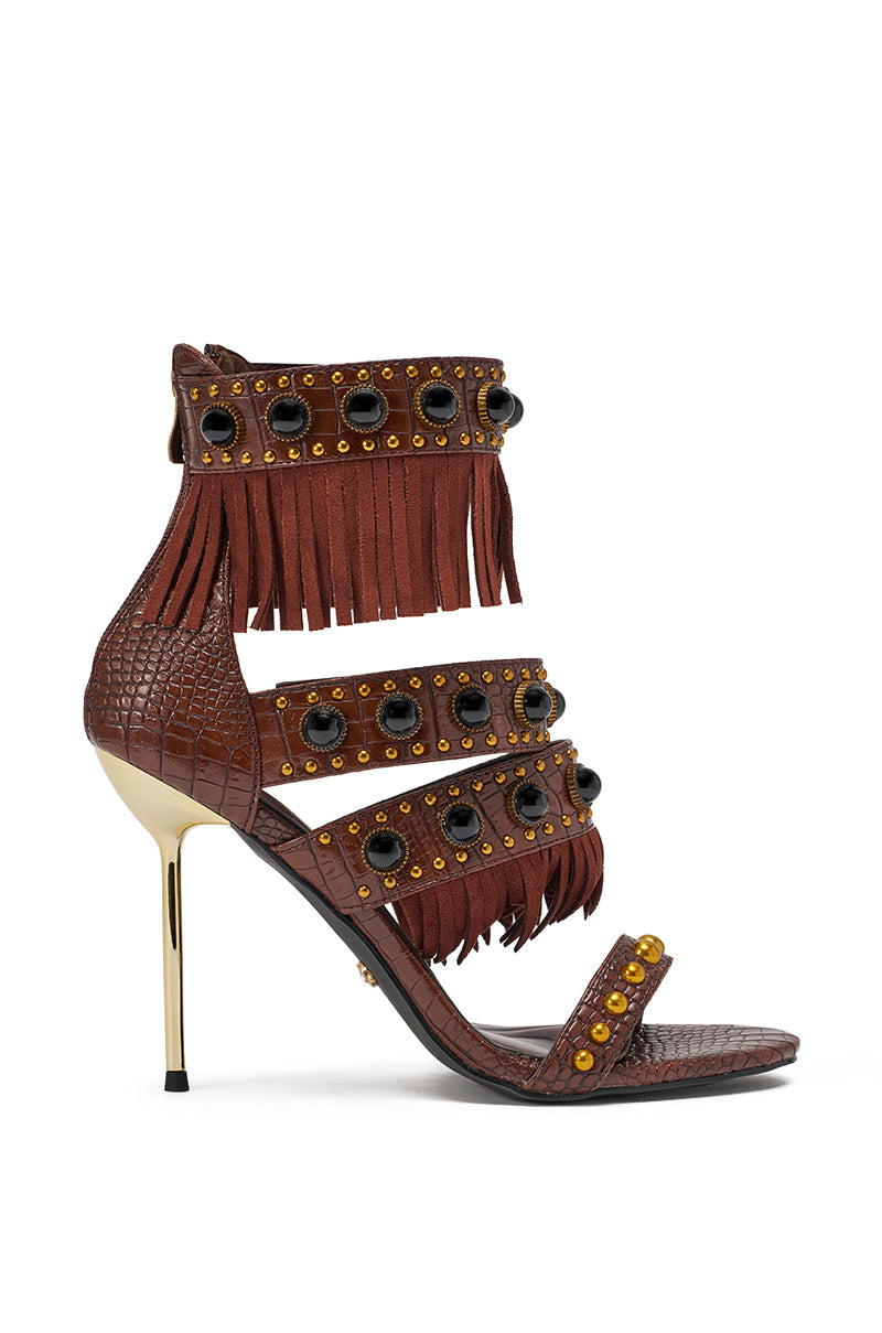 The AZALEA WANG ANTOINE BROWN FRINGE AND GOLD EMBELLISHED STILETTO HEEL features croc-embossed faux leather, a gold metallic heel, fringe accents, and black and gold studded ankle, midfoot, and toe straps. 4