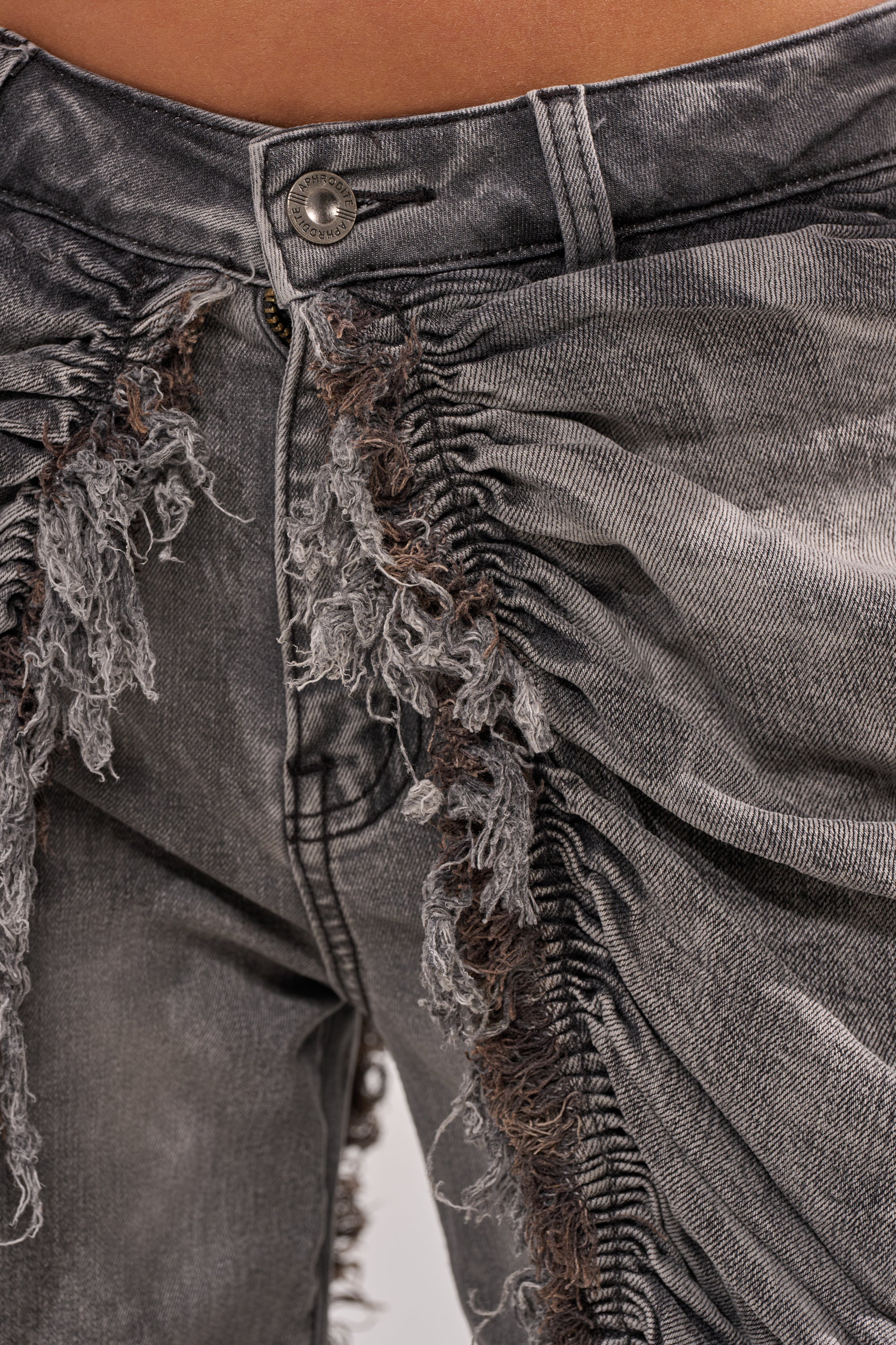 Close-up of the WOW WOW WOW DENIM PANT featuring distressed grey flare denim with ruched detailing, frayed seams, and gathered fabric accents near the zipper and upper thigh. 6