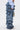 A person wearing the LOOK THIS WAY RUFFLE DENIM PANT, along with a light blue ruched-sleeve shirt and holding a small handbag, is shown from the lower torso and legs only.