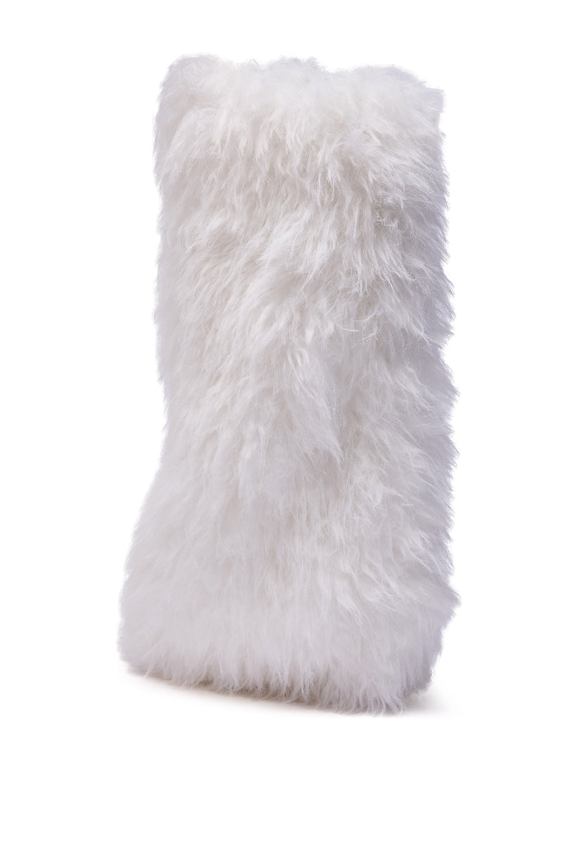 A rectangular, fluffy, white pillow with a shaggy faux fur texture stands upright against a plain white background, channeling the chic style of the AZALEA WANG ARETE WHITE FUR STILETTO BOOT.