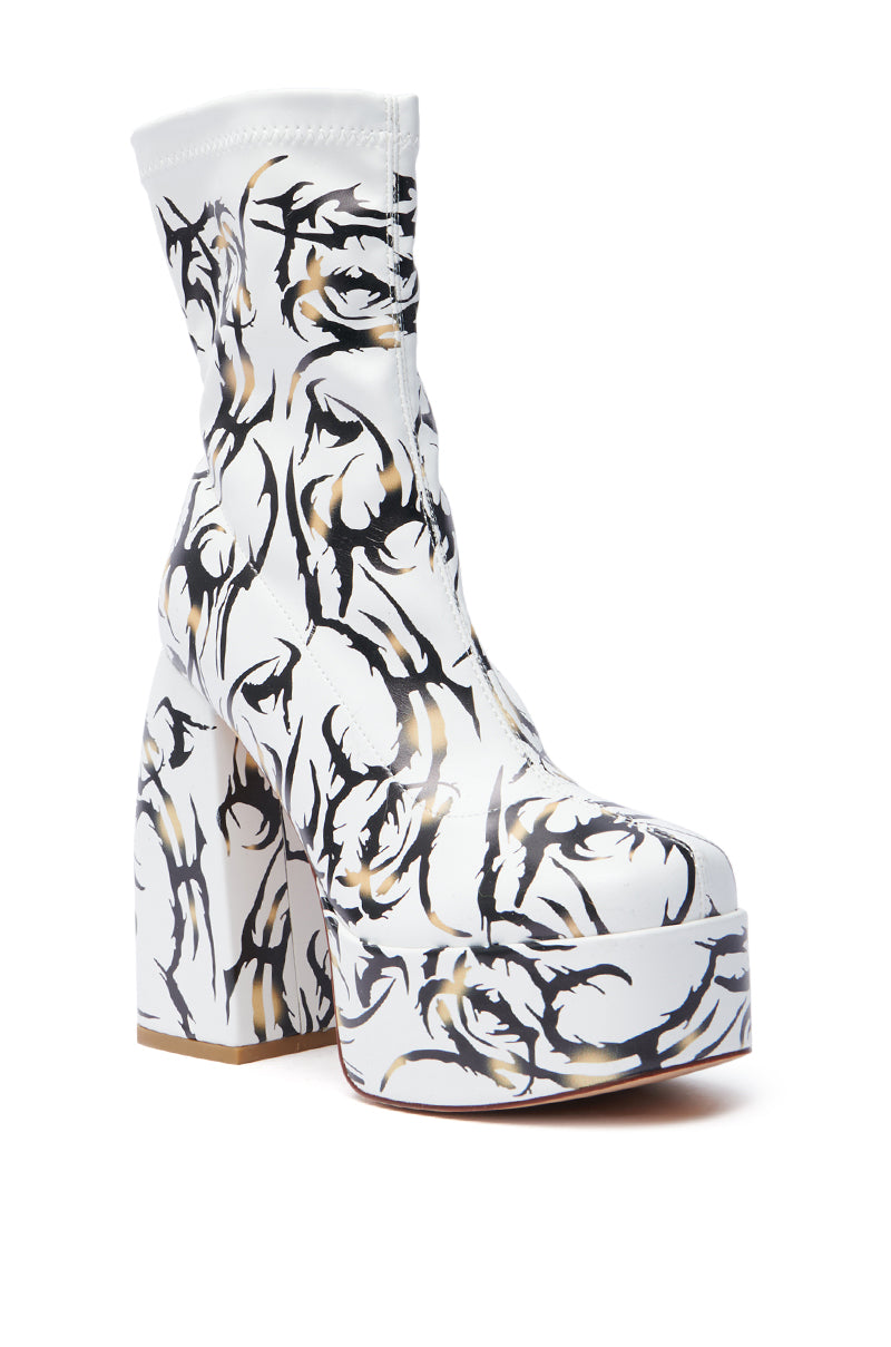 Discover the AZALEA WANG ARIADNE WHITE CHUNKY BOOTIE, an ankle-length boot with a platform sole and tattoo-inspired black and beige pattern. It features a thick high heel and convenient zip-up closure, blending modern art with fashion-forward design.