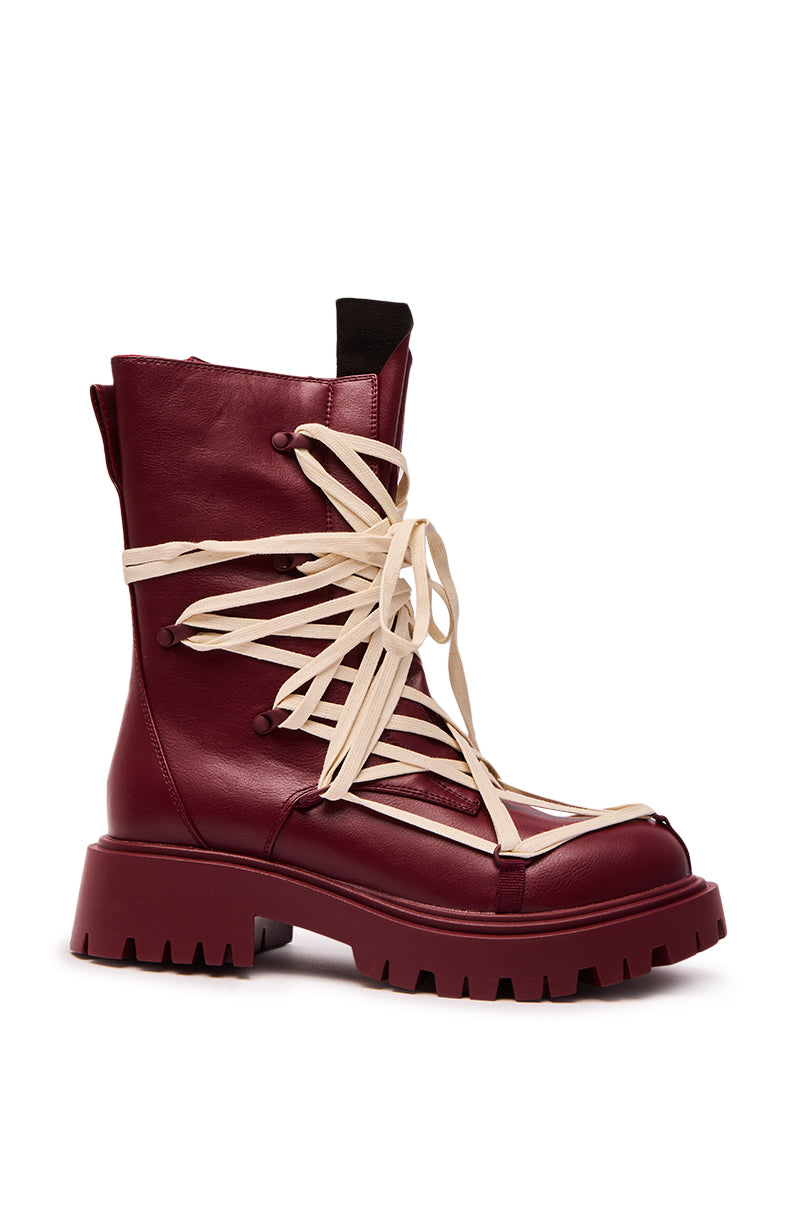 The AZALEA WANG ARJUN BURGUNDY LACE DETAIL BOOTIE features thick tan crisscross laces wrapping the ankle and front, a chunky treaded sole, and a stylish mid-calf height for an edgy look.