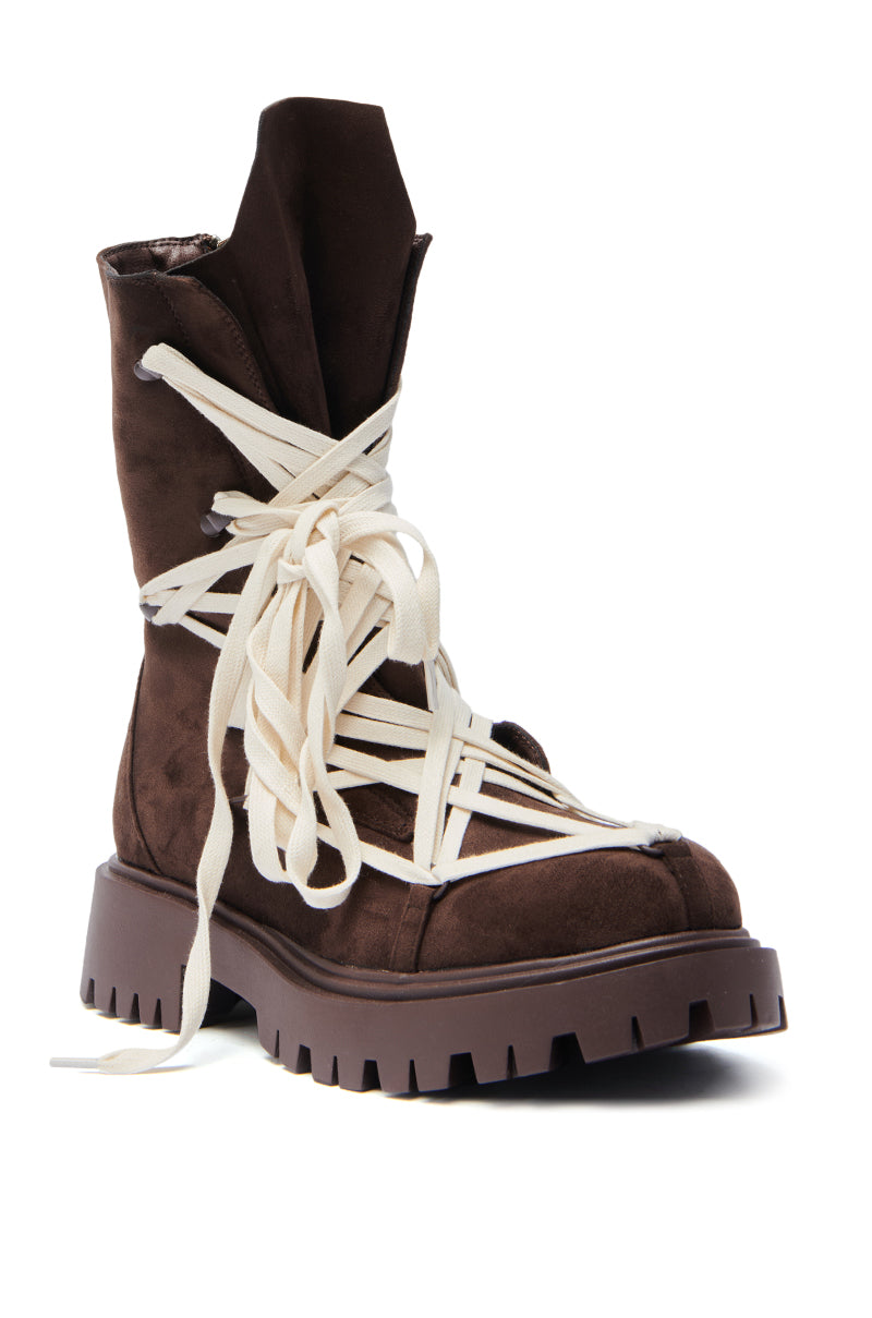 The AZALEA WANG Arjun Chocolate Lace Bootie features dark brown faux suede, chunky heels, a thick ridged sole, and oversized white laces crisscrossing up and around the boot.