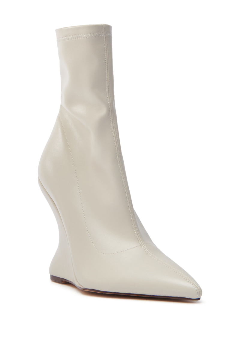 The AZALEA WANG ARKETTA bootie features a cream hue, high faux leather heel, pointed toe, and unique abstract wedge. It's crafted from smooth material with an elegant front seam. 3