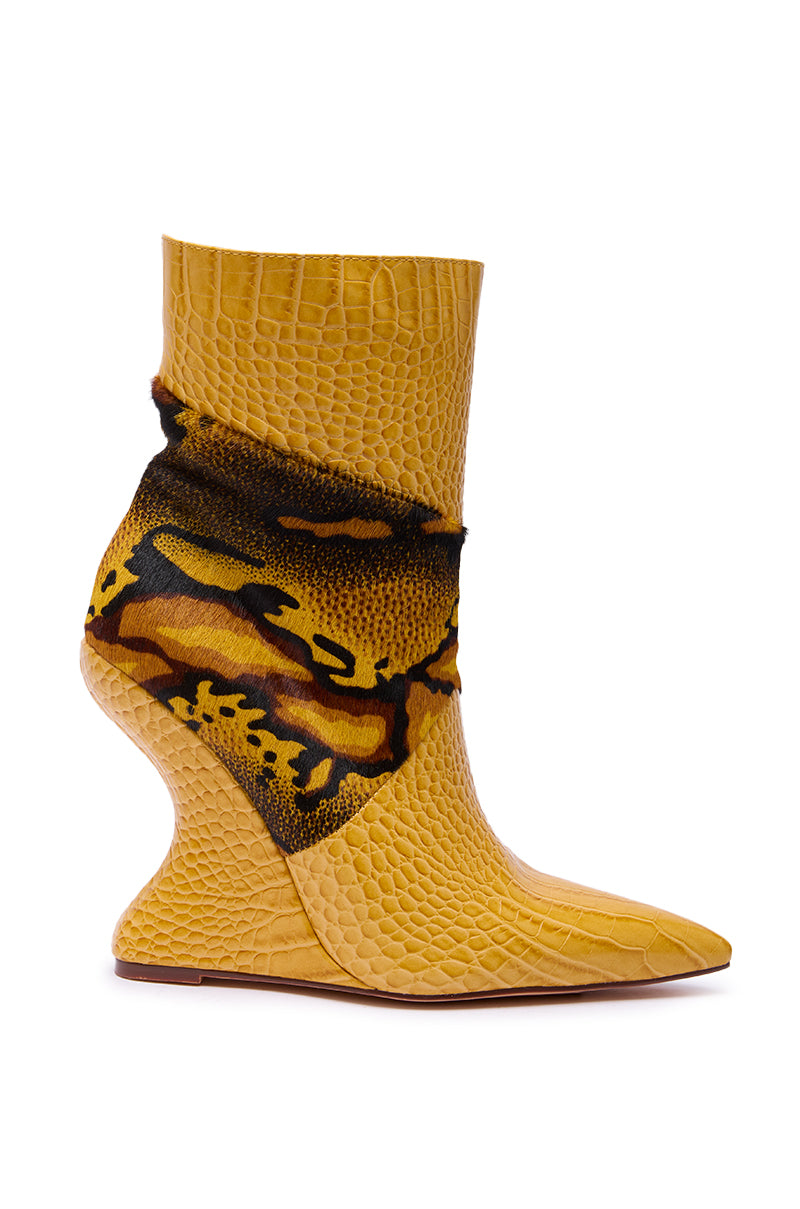 The AZALEA WANG ARTOUL Yellow Color Blocked Wedge Bootie features a crocodile texture, pointed toe, flared sculptural heel, and a multicolor fuzzy band in brown, black, and yellow around the ankle.