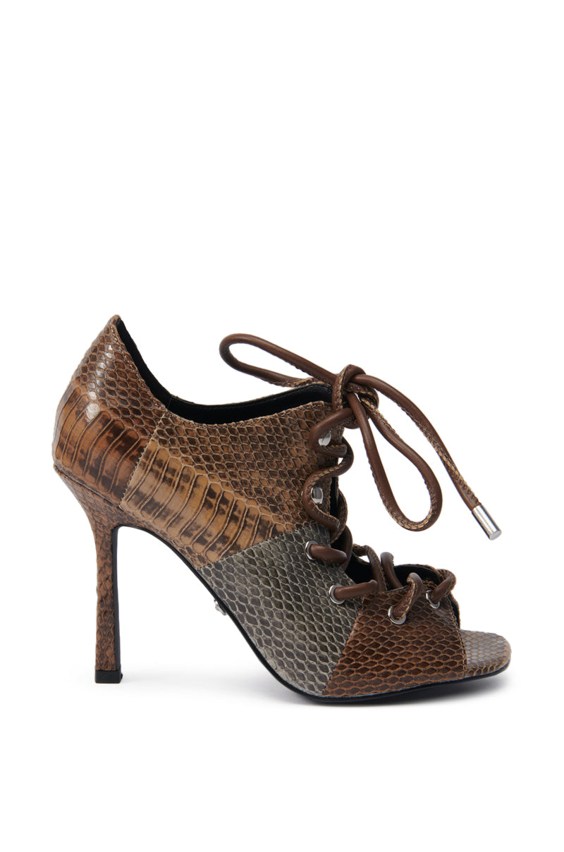 The AZALEA WANG ASHLIE COLOR BLOCKED SNAKE SANDAL is a high-heeled, open-toe sandal with a lace-up front and a brown and tan faux leather snakeskin pattern. 3