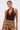 A woman with slicked-back hair wears large hoop earrings, the GROOVING AND MOVING BODYSUIT featuring a brown halter neckline and ring detail, paired with a patterned brown, gold, and cream skirt against a plain white background.