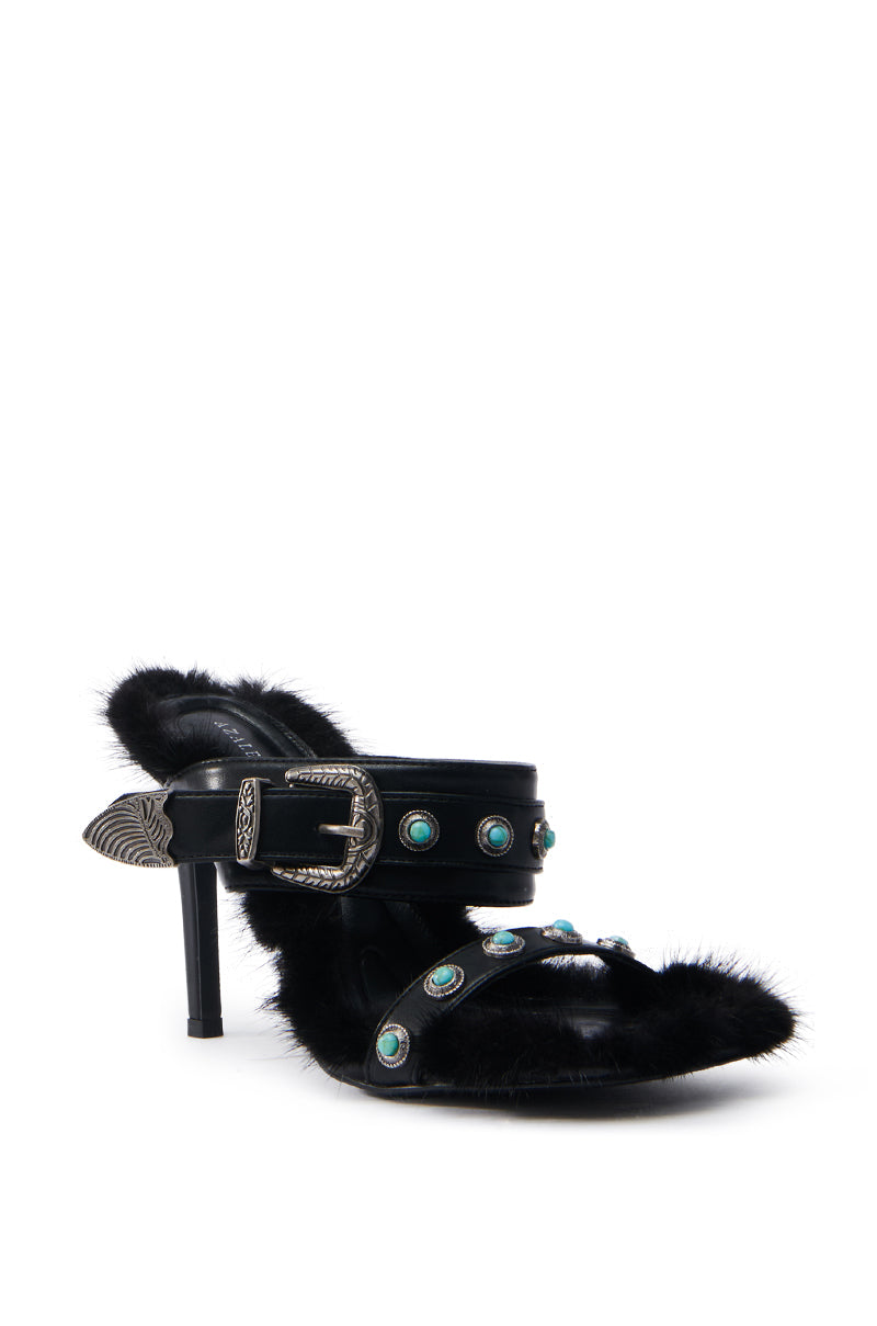 The AZALEA WANG AUGER BLACK SANDAL has a black stiletto heel with faux fur, turquoise stones, and ornate silver buckles. It features a pointed toe, stylish front strap, and silver embellishment on the heel for an elegant yet modern look.