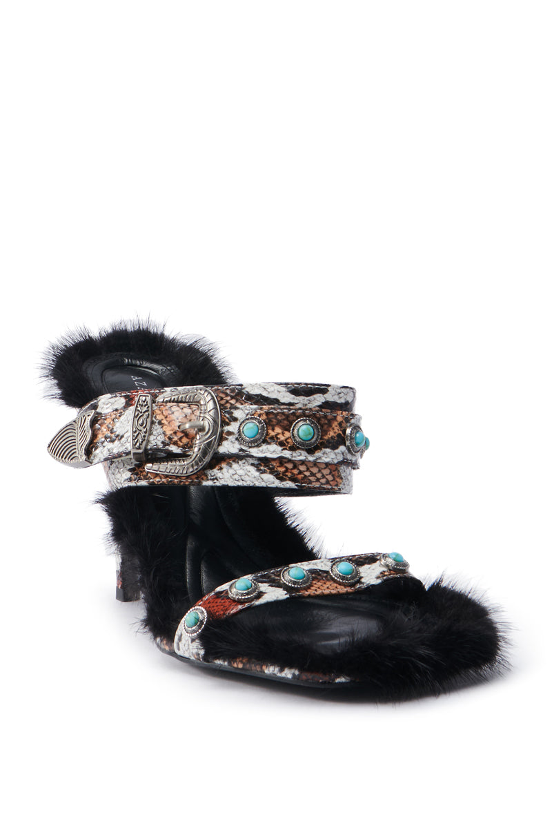 The AZALEA WANG AUGER BROWN SANDAL features a high heel with a striking snakeskin pattern, turquoise stone embellishments, a decorative buckle strap, and plush black fur lining around the heel and sole. Made from vegan leather for an ethical finish.