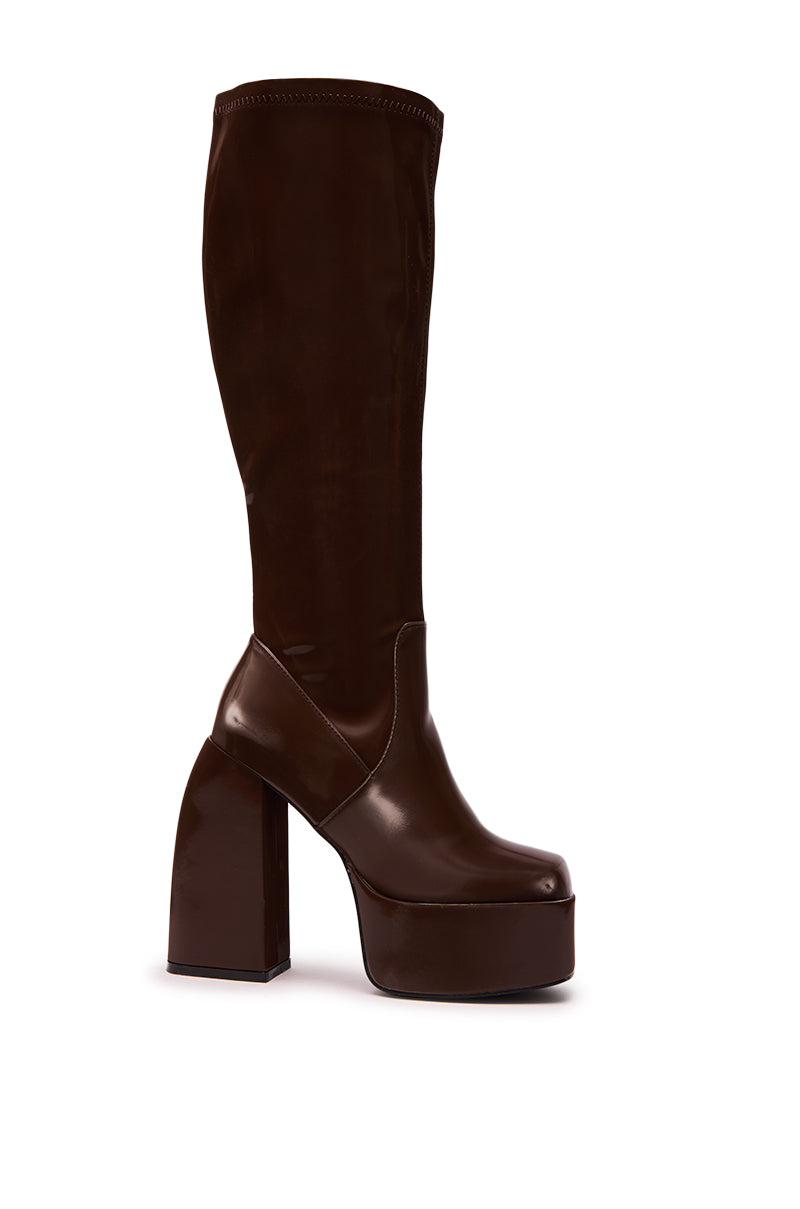 The AZALEA WANG AURON BROWN LIQUID LUXE PLATFORM BOOT features shiny faux patent leather, a chunky high heel, and thick sole in a knee-high design, shown against a white background.
