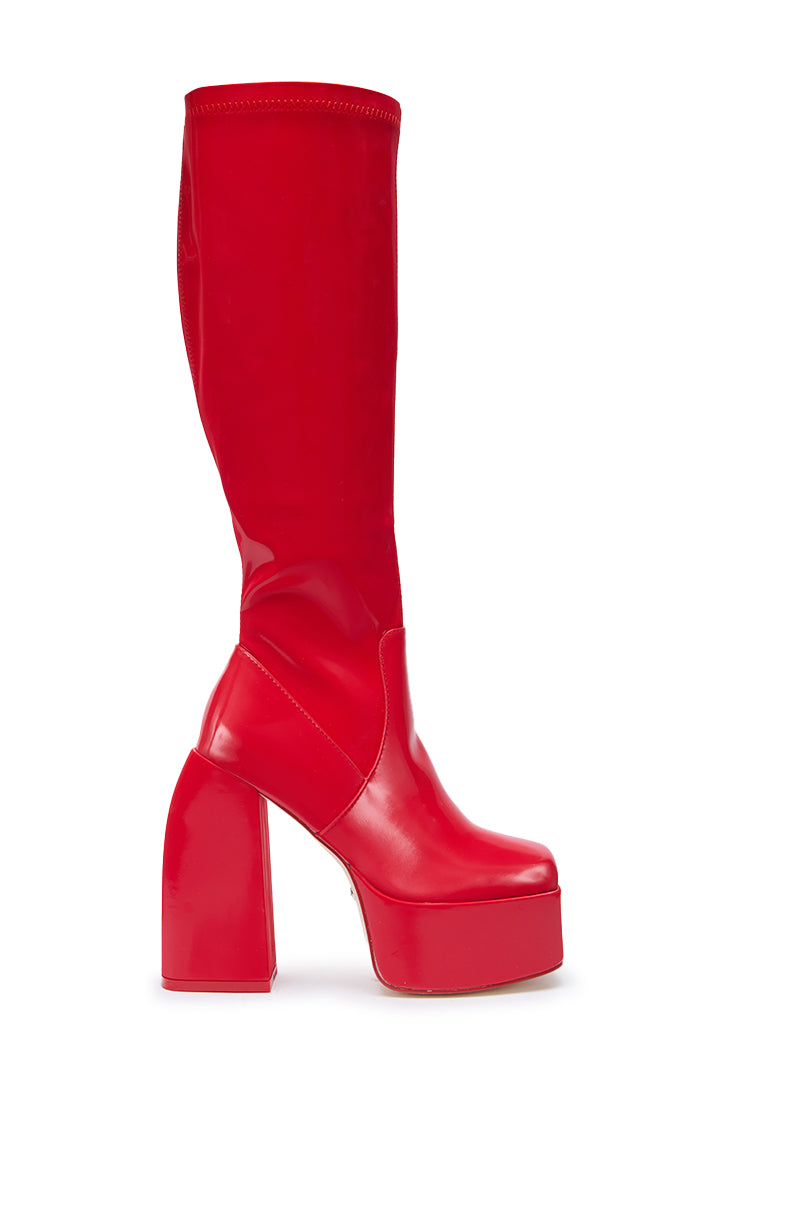 The AZALEA WANG AURON Red Liquid Luxe Platform Boot is a single knee-high, bright red faux patent leather boot with a chunky high heel, shown from the side against a white background.