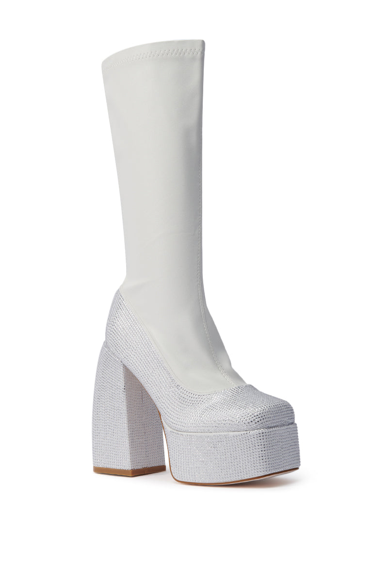 Step out in the AZALEA WANG AURONNE WHITE AND RHINESTONE CHUNKY BOOT—a knee-high white boot featuring a stretchy faux leather upper and chunky, glittery silver platform sole for standout style.