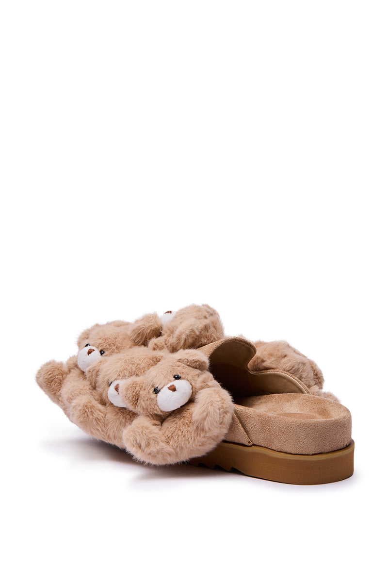 The AZALEA WANG AURORA BEIGE TEDDY BEAR CLOG features a tan, plush design with 3D bear embellishments on the soft, furry upper, displayed from a rear side angle against a white background.