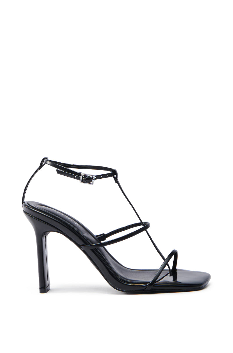 The AZALEA WANG AVENA BLACK PAT SANDAL is a vegan leather, high-heeled sandal with thin straps and an ankle buckle, shown against a white background.