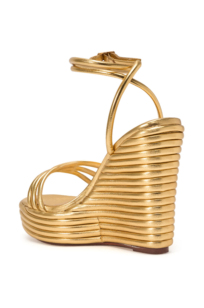 The AZALEA WANG AVENY Gold Strap Round Toe Wedge Sandal features a metallic gold finish, comfort cushion wedge heel, ridged sculptural platform, and ankle strap, shown from a side angle. 5