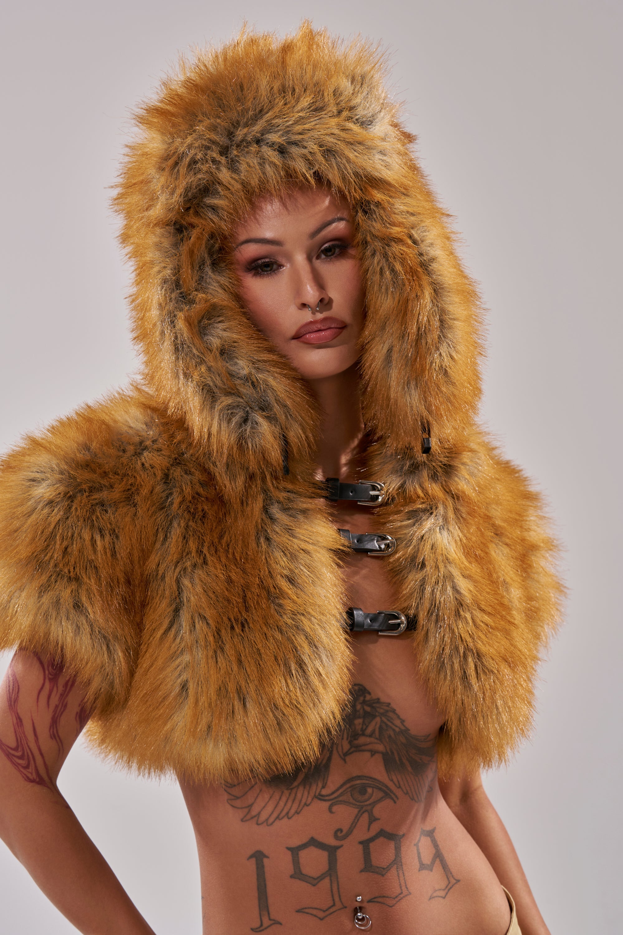 A person wearing the SO WITH IT FAUX FUR AVIATOR HAT poses against a plain light background, showing tattoos on their chest and arm. 8