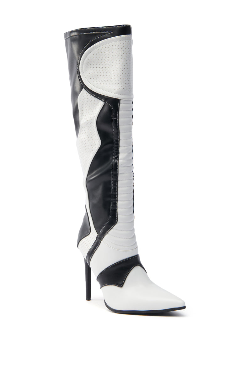The AZALEA WANG RODRIGO BLACK AND WHITE BOOT STILETTO is a knee-high vegan leather boot featuring a pointed toe, bold two-tone design in black and white, textured and smooth panels, decorative stitching, and a sleek modern look.