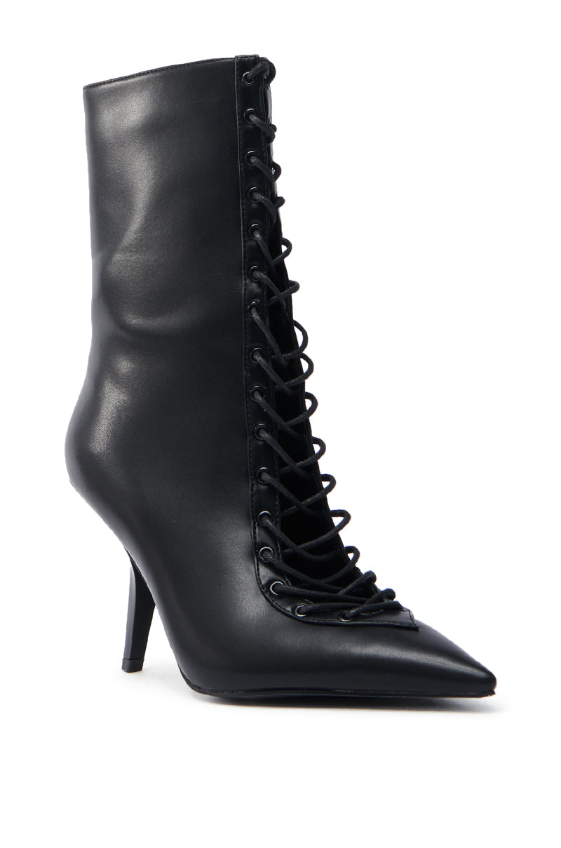 The AZALEA WANG SILVA BLACK LACE UP STILETTO BOOTIE is a sleek faux leather mid-calf boot featuring a pointed toe and stylish central lace-up panel with black laces.