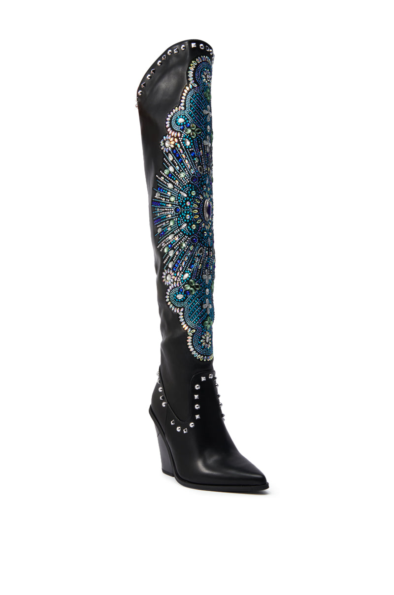 The AZALEA WANG AXELBEAT BLACK EMBELLISHED WESTERN BOOT features a black over-the-knee silhouette with a pointed toe, wedge heel, silver studs, and bold blue and turquoise beading that delivers eye-catching Western-inspired style.