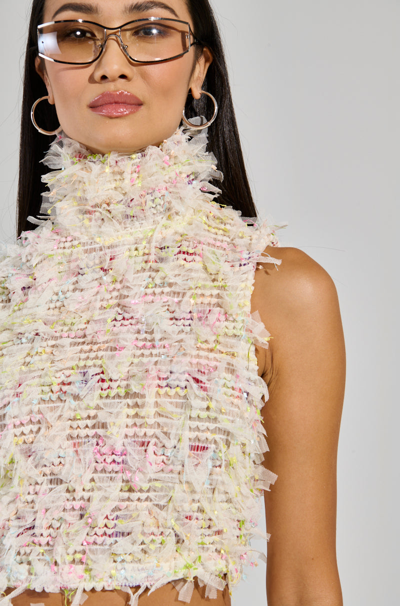 A person wearing a vibrant Sweet Like Candy Sleeveless Top and large, round sunglasses. Their long, dark hair flows smoothly, complementing the statement hoop earrings. The backdrop is plain and light-colored, drawing attention to their chic style.