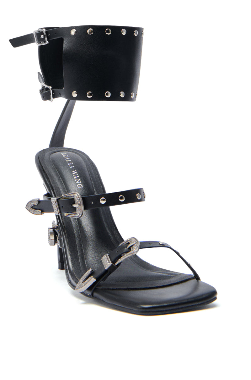 The AZALEA WANG AYBARS BLACK CUFFED SANDAL features a studded ankle cuff with silver studs, two slim Western buckles over the foot, a square toe, and "ALEX WANG" on the insole.