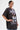 A woman with wet-look short hair, bold earrings, and a large cross necklace poses confidently in the AALIYAH FOREVER GRAPHIC TSHIRT DRESS—a perfect pop icon tribute for your streetwear collection.
