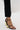 A person wearing black pants and AZALEA WANG AYYAR BLACK GOLD WEDGE HEEL SANDALS featuring geometric novelty wedge heels, standing on a white surface.