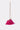 The TICKLED PINK PURSE is a small, bright accessory adorned with fuchsia feathers, featuring a gold chain strap and metallic clasp, shown against a plain light background.
