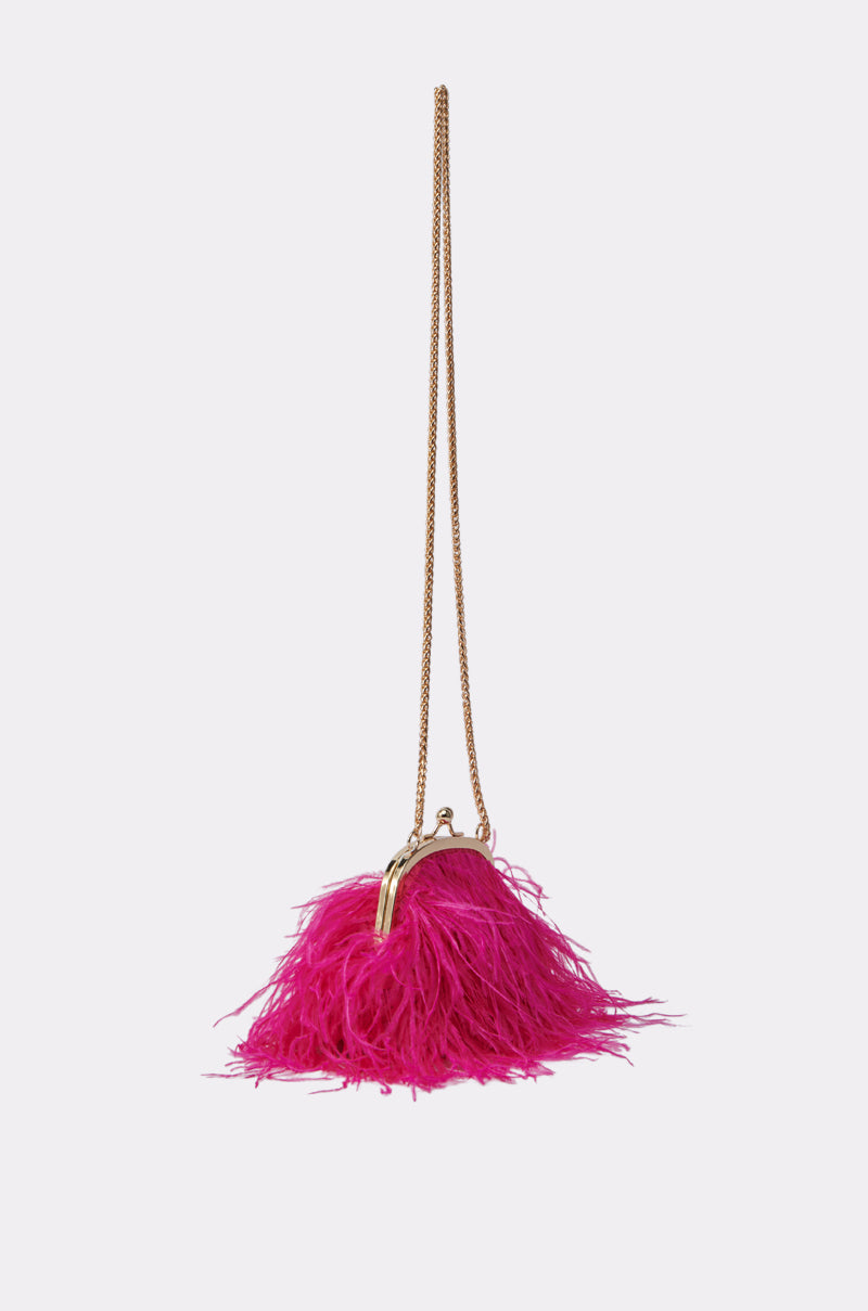 The TICKLED PINK PURSE is a small, bright accessory adorned with fuchsia feathers, featuring a gold chain strap and metallic clasp, shown against a plain light background. 3