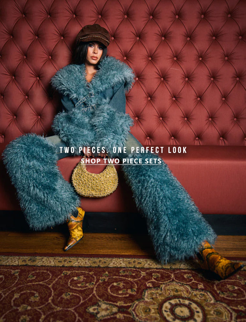 Person wearing a blue outfit sitting on a red tufted sofa with text TWO PIECES. ONE PErFECT LOOK. shop two piece sets