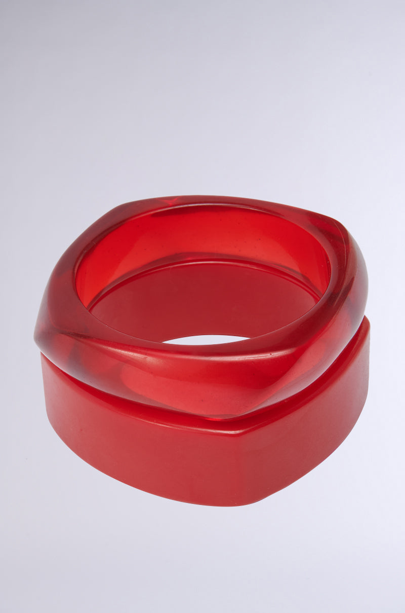 The SUMMER TIME FINE BRACELET SET features chunky, glossy red resin bangles with an angular, sculptural design, displayed against a light gray background. 3