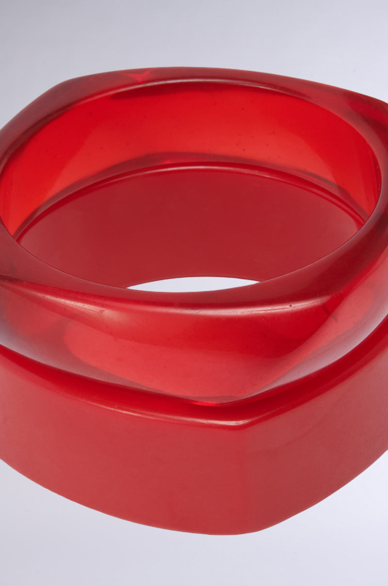 The SUMMER TIME FINE BRACELET SET features a chunky, translucent red resin bangle with a smooth geometric sculptural design, set against a light gray background—ideal for adding bold style to your bracelet stack. 4